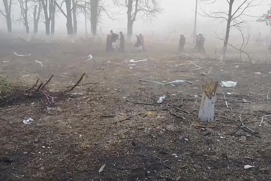 Civilians walk through a devastated forest during their evacuation from the area of Sudzha town, which was recently retaken by Russia's armed forces in the course of Russia-Ukraine conflict in the Kursk region, Russia, in this still image from video released March 16, 2025. Russian Defence Ministry/Handout via REUTERS/File Photo
