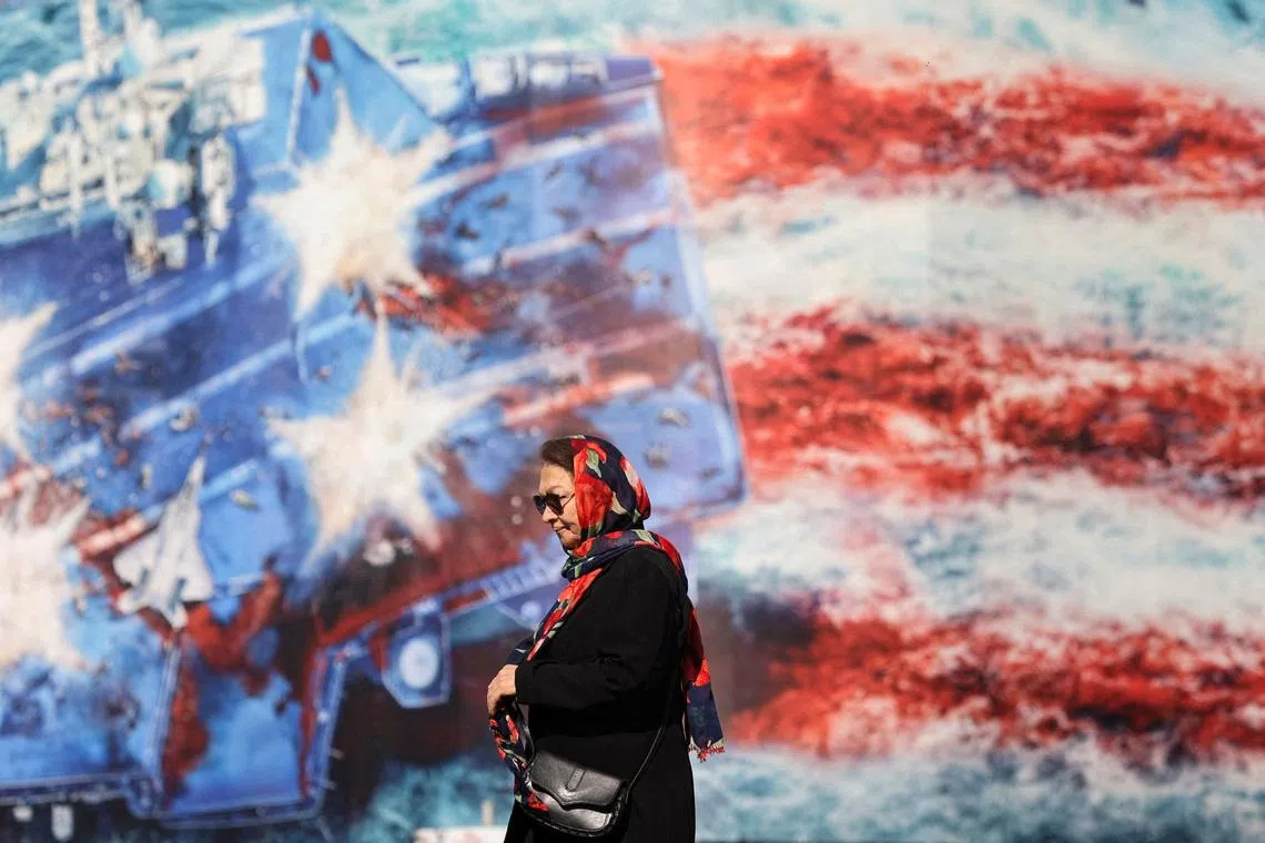 An Iranian woman walks past an anti-U.S. billboard in Tehran, Iran, February 26, 2026. Majid Asgaripour/WANA (West Asia News Agency) via REUTERS