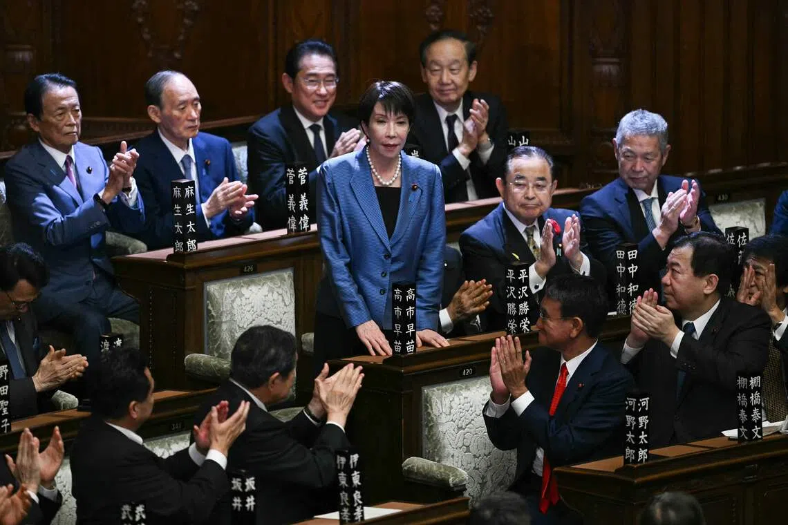 Liberal Democratic Party President Sanae Takaichi stands up to acknowledge the applause after she was selected as Japan's new prime minister on Oct 21.