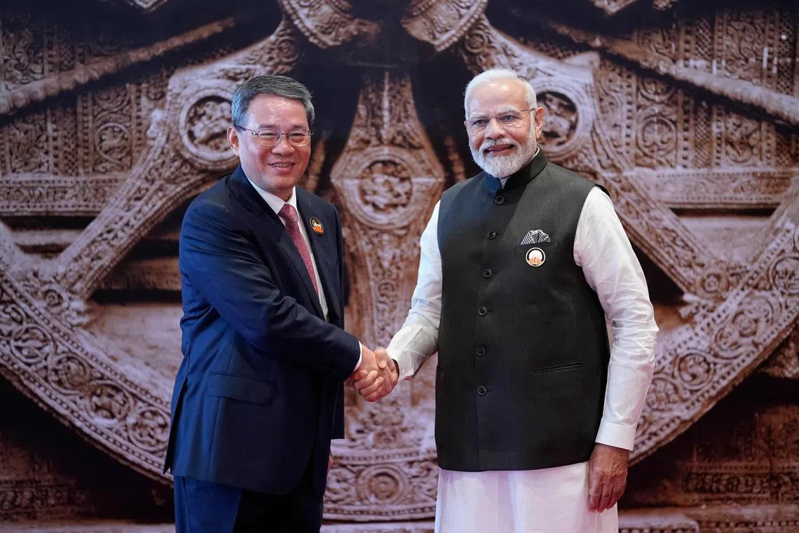 India's Prime Minister Narendra Modi (R) shakes hand with Chinese Premier Li Qiang ahead of the G20 Leaders' Summit in New Delhi on September 9, 2023. (Photo by Evan Vucci / POOL / AFP)