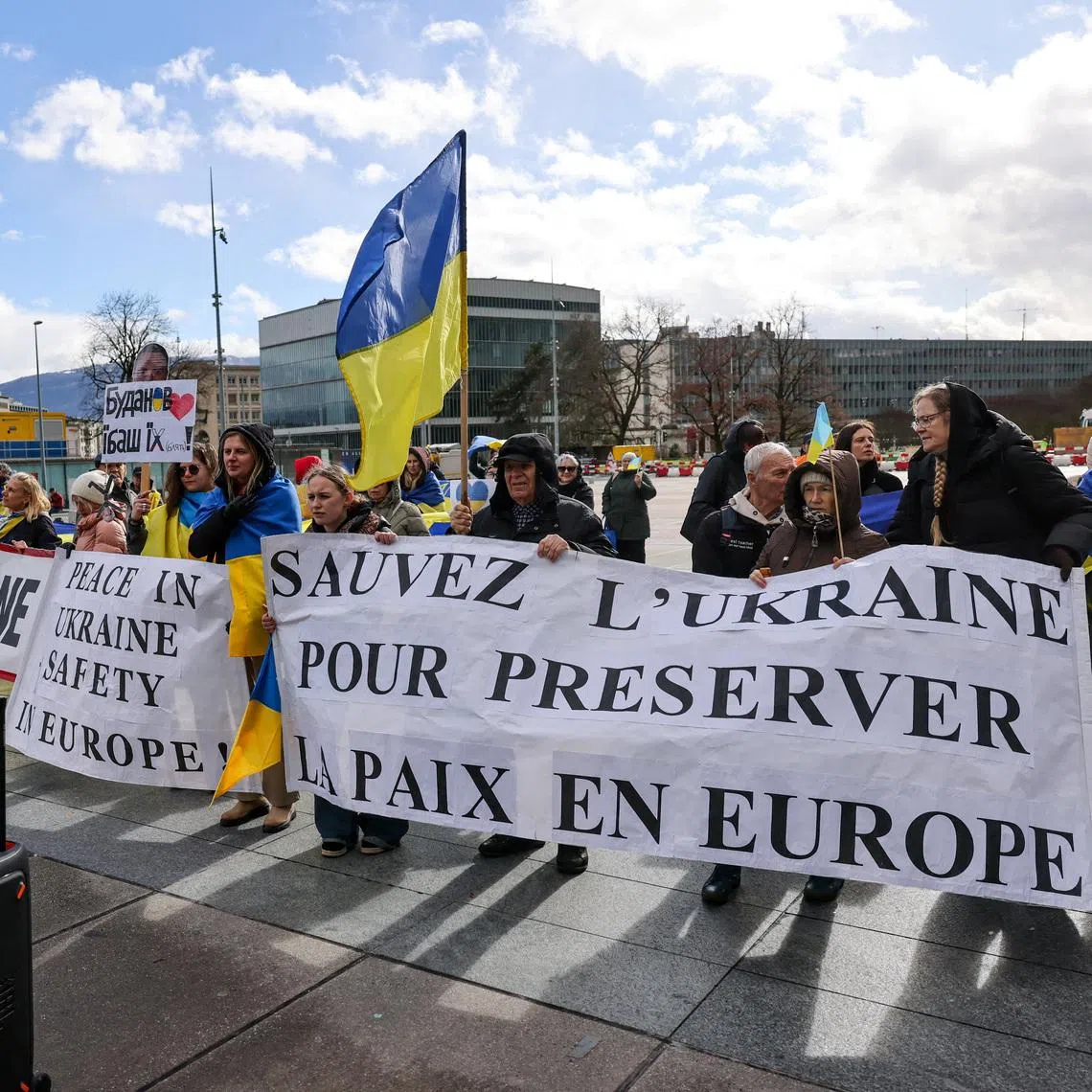 FILE PHOTO: People carry banners at a protest near the United Nations office, on the day of U.S.-mediated peace talks between Russia and Ukraine in Geneva, Switzerland, February 17, 2026. The banner on the right reads: \"Save Ukraine to preserve peace in Europe\". REUTERS/Pierre Albouy/File Photo