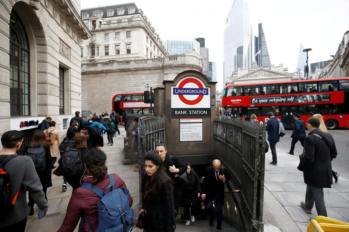 A 2020 photo shows commuters emerging from the London Underground station called Bank, in the City of London financial district.
