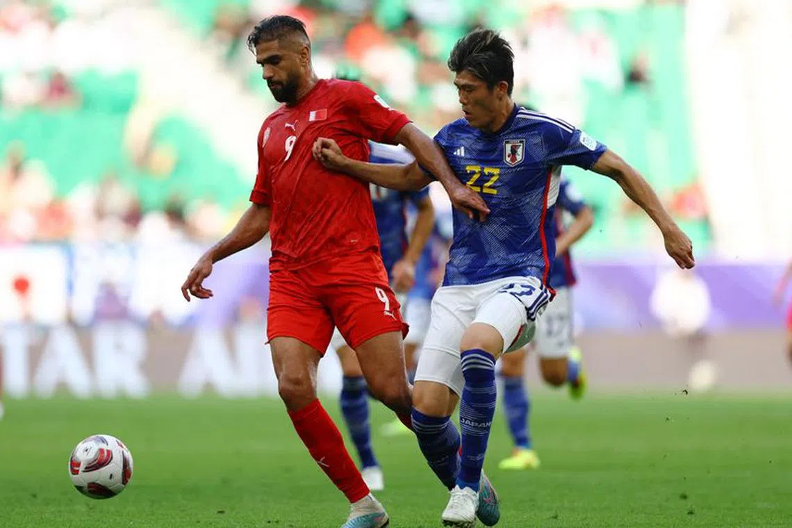 Soccer Football - AFC Asian Cup - Round of 16 - Bahrain v Japan - Al Thumama Stadium, Doha, Qatar - January 31, 2024 Japan's Takehiro Tomiyasu in action with Bahrain's Abdulla Yusuf Helal REUTERS/Molly Darlington