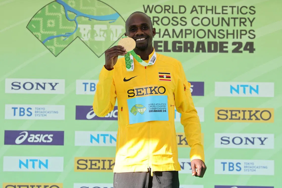 Uganda's Jacob Kiplimo celebrates on the podium with the gold medal after winning the men's race.