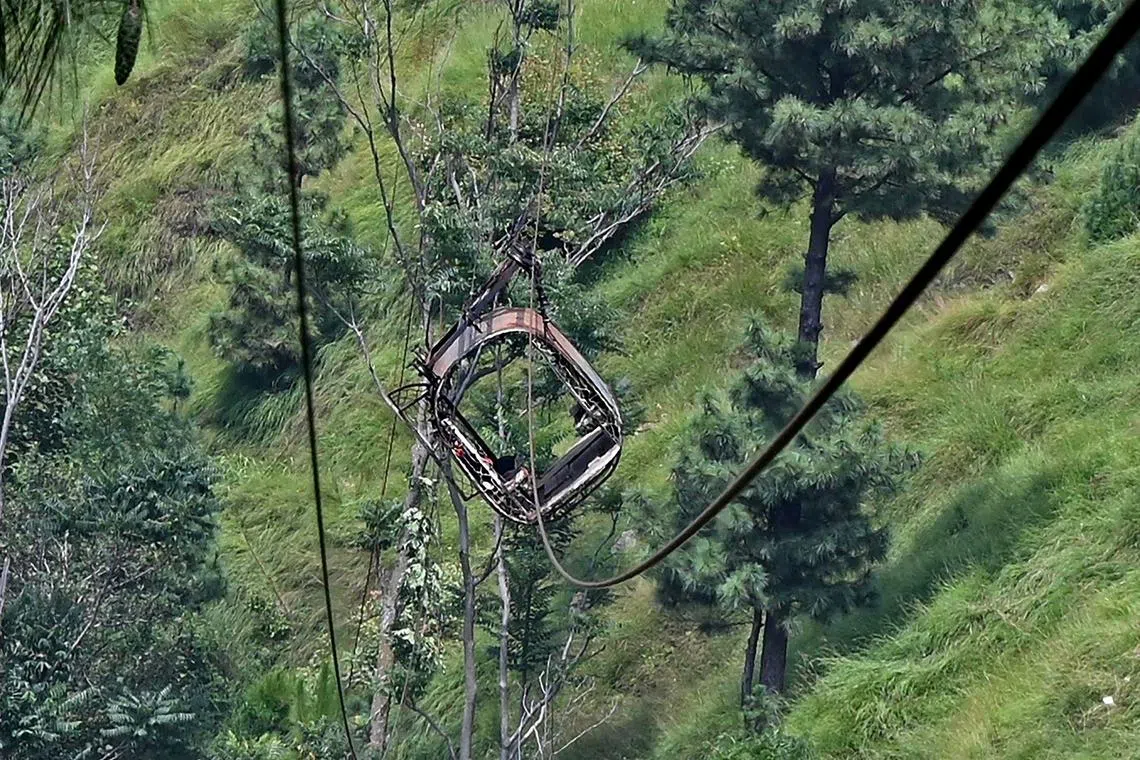 This photograph shows a view of the chairlift cable in the Pashto village of mountainous Khyber Pakhtunkhwa province on August 23, 2023, a day after it broke sending passengers plunging into a ravine. Military helicopters and ziplining commandos rescued eight people, including six schoolboys, who were trapped for hours on August 22, in a stricken cable car high above a remote Pakistani valley. (Photo by Farooq NAEEM / AFP)