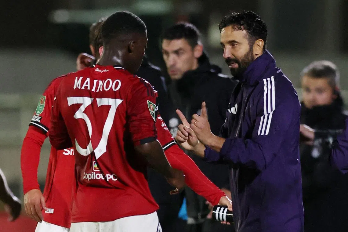 Manchester United manager Ruben Amorim talking to Kobbie Mainoo during United's match against Grimsby Town in the second round of the League Cup.