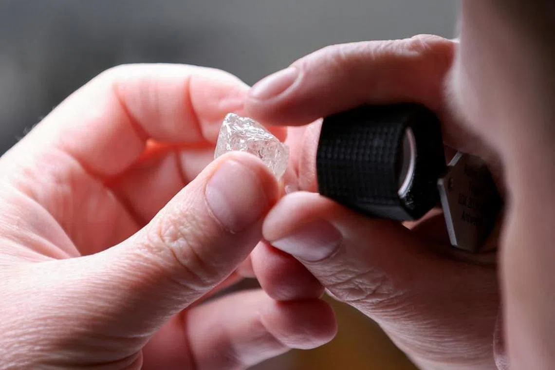 FILE PHOTO: An employee holds a rough diamond at \"Diamonds of ALROSA\" factory in Moscow, Russia April 30, 2021. REUTERS/Tatyana Makeyeva//File Photo