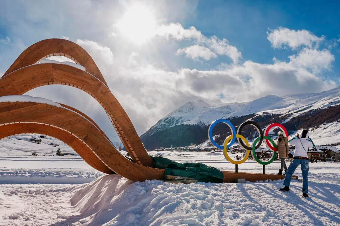 People take pictures at the Olympic rings in Livigno, Italy, ahead of the Milan-Cortina Winter Games.