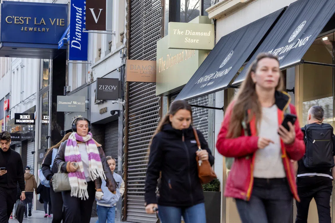 People walk past diamond shops in the city centre of Antwerp, Belgium November 7, 2025. REUTERS/Geert Vanden Wijngaert