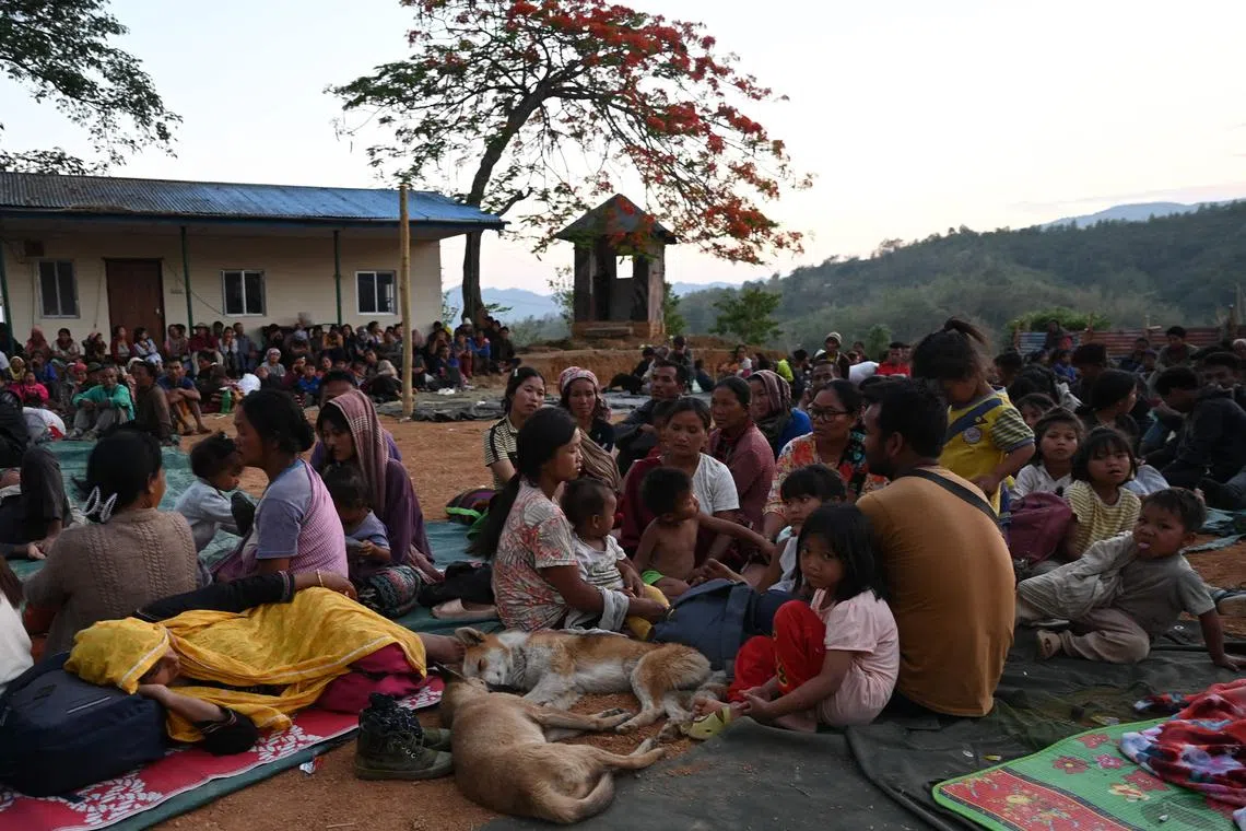People waiting at a temporary shelter in a military camp, after being evacuated by the Indian army, as they fled ethnic violence that hit the north-eastern Indian state of Manipur on Sunday. 