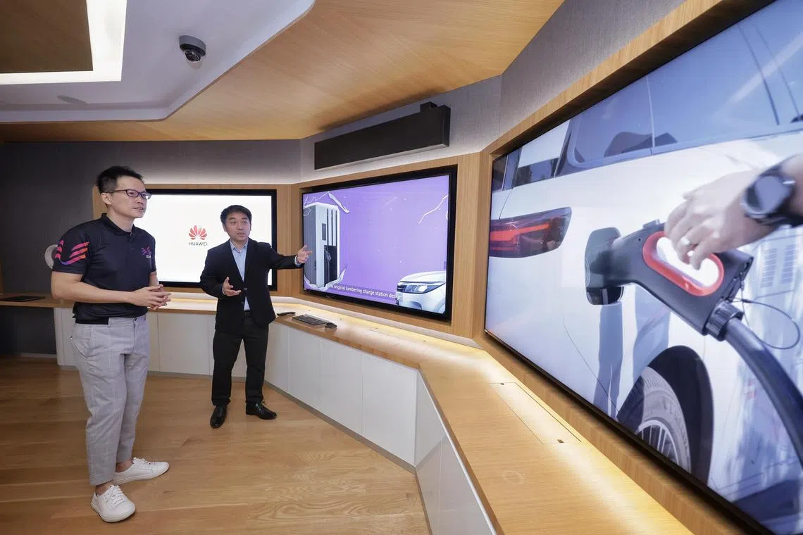(From left) EVe CEO Derek Tan and managing director of Huawei Digital Power Singapore Terry Gao watching a video presentation of the state grid Xiahuayuan ultra-fast charging station in China during the MOU signing, for the trial of liquid-cooled ultra-fast charger for electric vehicles, between Land Transport Authority subsidiary EV-Electric and Huawei at Huawei AI Lab on March 18, 2024. ST PHOTO: KEVIN LIM nteve18