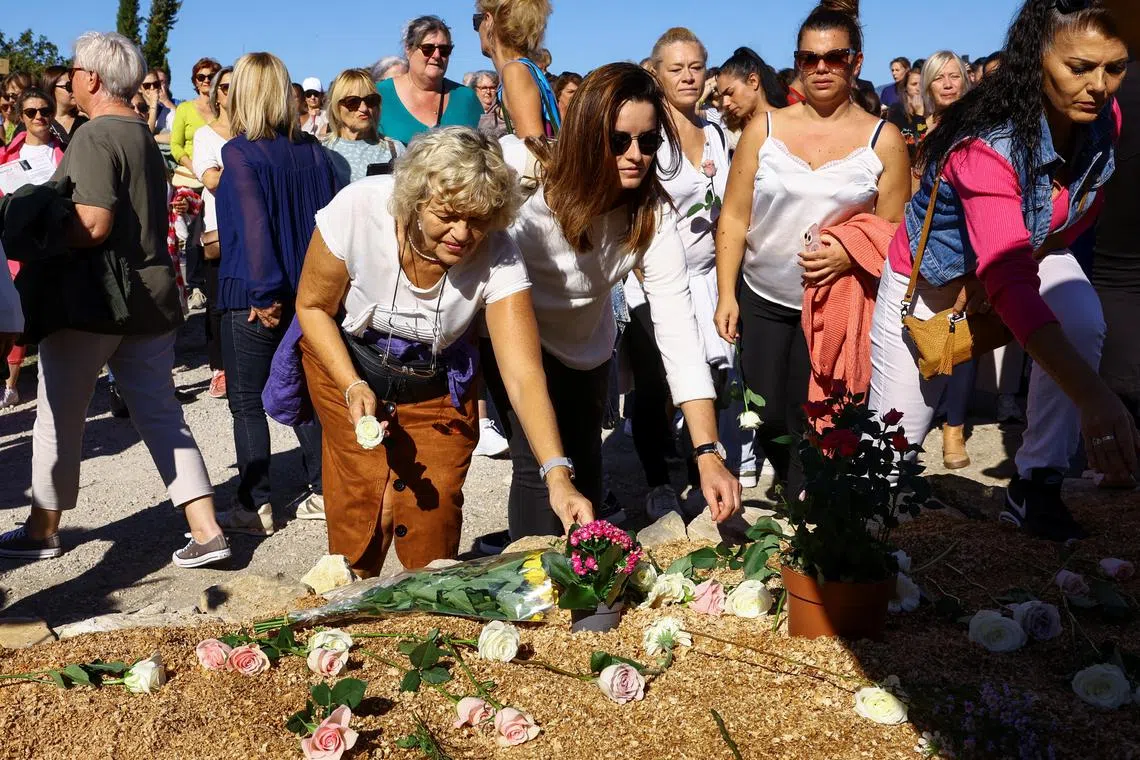 FILE PHOTO: Women lay flowers in a tribute during a silent march to support Gisele Pelicot, who has allegedly been drugged and raped by men solicited by her husband Dominique Pelicot at their home, and other female victims of violence, as the trial of Frenchman Pelicot and 50 co-accused continues, in Mazan, France, October 5, 2024. REUTERS/Manon Cruz/File Photo