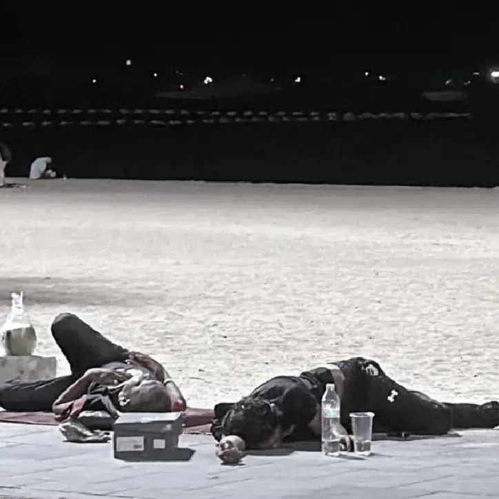 A large number of homeless people were scattered along Pattaya Beach, resting or sleeping at various spots. 