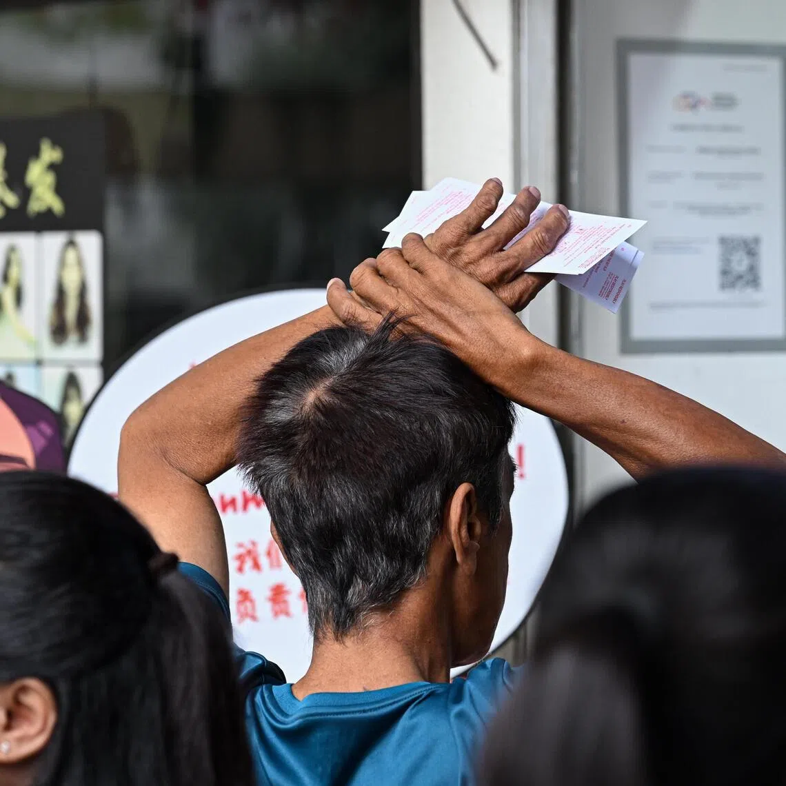 Foreign workers at a Singapore Pools outlet at City Plaza on July 12.