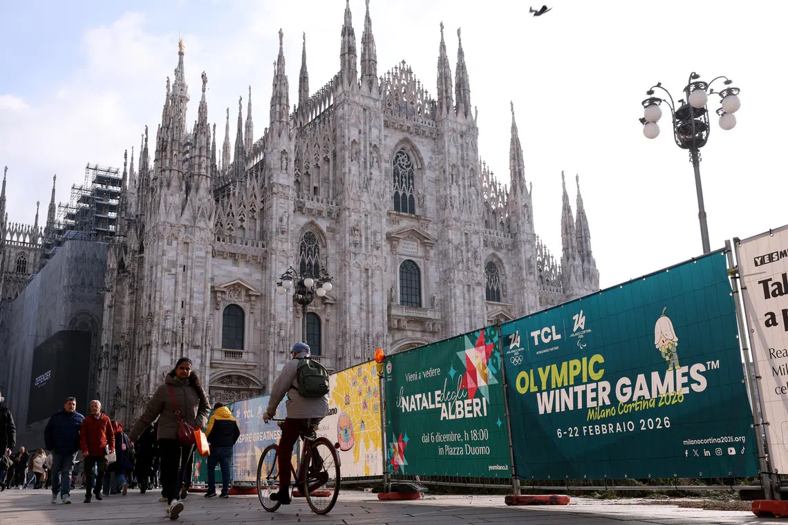 Olympics - 2026 Milano-Cortina Winter Olympics - Milan, Italy - November 20, 2025 People walk next to an Olympic Winter Games Milano Cortina 2026 advertising, in front of the Duomo cathedral REUTERS/Claudia Greco