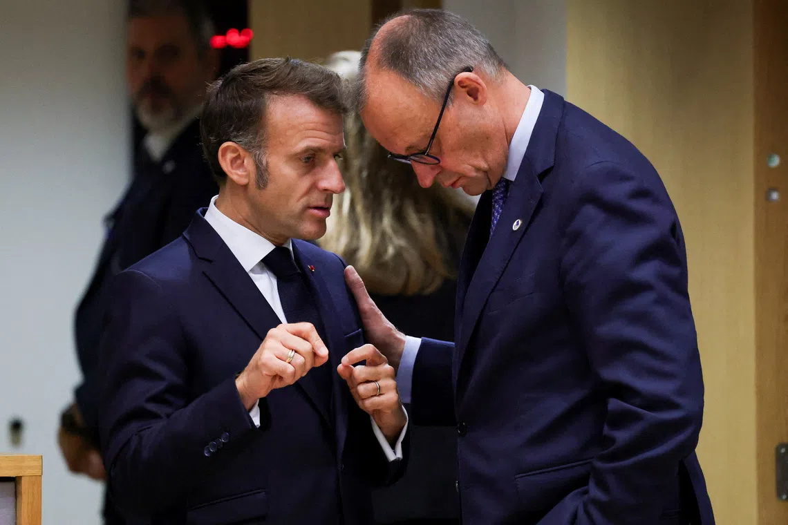 FILE PHOTO: French President Emmanuel Macron and German Chancellor Friedrich Merz interact as they attend the European Union leaders' summit in Brussels, Belgium, October 23, 2025. REUTERS/Yves Herman/ File Photo