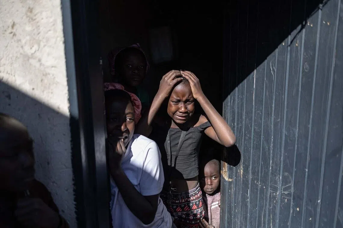 TOPSHOT - Children react after being confronted by protesters during an anti-migrant protest in Alexandra on July 16, 2026. Protest organisers and participants have vowed to continue holding demonstrations every Thursday as part of an ongoing anti-migrant campaign. (Photo by EMMANUEL CROSET / AFP)