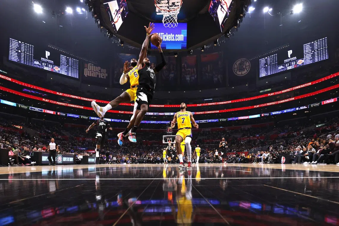 LOS ANGELES, CALIFORNIA - NOVEMBER 09: Paul George #13 of the LA Clippers is fouled by LeBron James #6 of the Los Angeles Lakers as he attempts to score on a layup during a 114-101 Clippers win at Crypto.com Arena on November 09, 2022 in Los Angeles, California. NOTE TO USER: User expressly acknowledges and agrees that, by downloading and or using this Photograph, User is consenting to the terms and conditions of the Getty Images License Agreement. Mandatory Copyright Notice: Copyright 2022 NBAE.   Harry How/Getty Images/AFP
