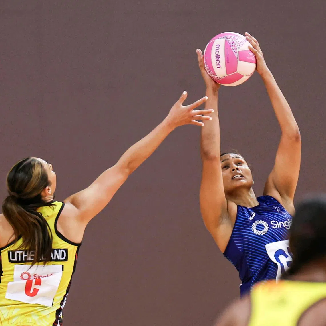 ST20251103_202567600407/kknet03/Brian Teo/Kimberly Kwek MR/Singapore's goalkeeper Reena Divya (right) snatching the ball from Papua New Guinea centre Chloe Litherland (left) during the Singlife Nations Cup at OCBC Arena Hall 1 on Nov 3, 2025. ST PHOTO: BRIAN TEO