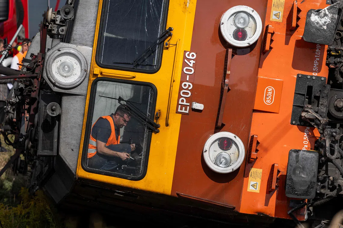 Police officers, firefighters and investigators work at the site where a passenger train collided with a lorry at a level crossing in the village of Sokolniki Suche, south-eastern Poland on September 9, 2026. A train carrying 120 passengers collided with a cement truck and derailed in east-central Poland, killing one passenger and leaving several injured, local authorities said Wednesday. (Photo by Wojtek RADWANSKI / AFP)