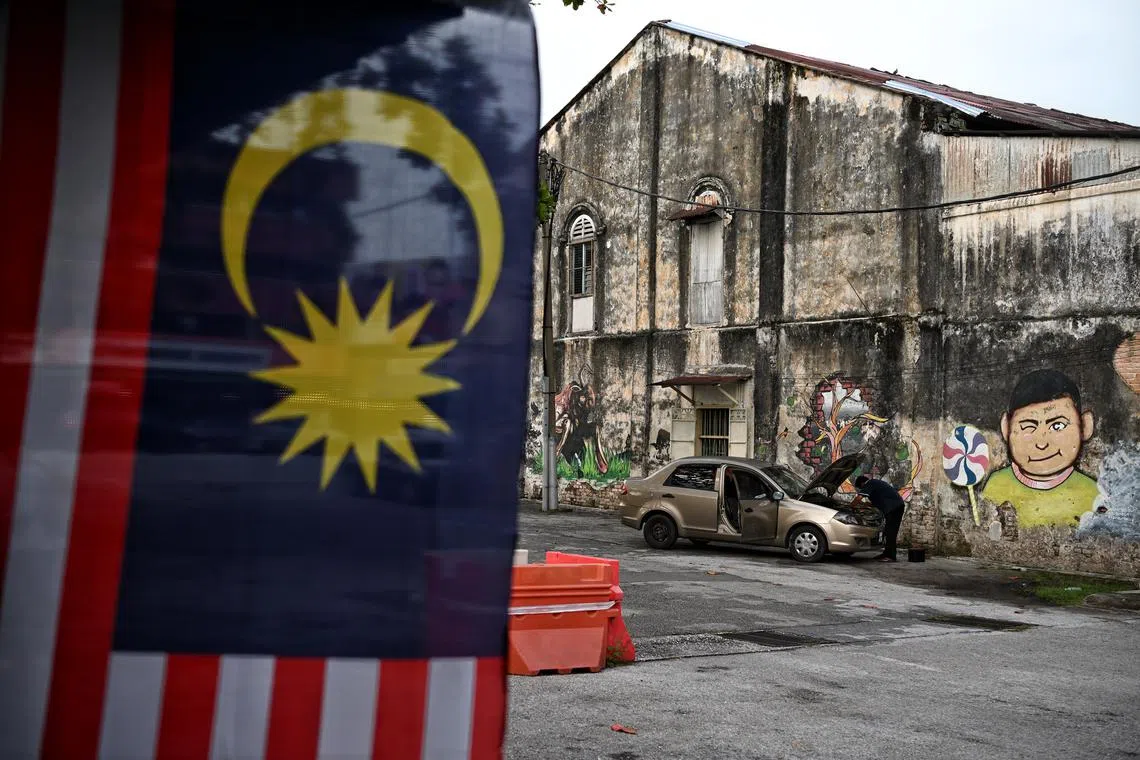 A man repairing his car in Tambun, in Perak, Malaysia, on Wednesday. Nearly a third - or 31 per cent - of voters are undecided or have no preference for a candidate in the upcoming election on Nov 19, according to the Merdeka Centre. 