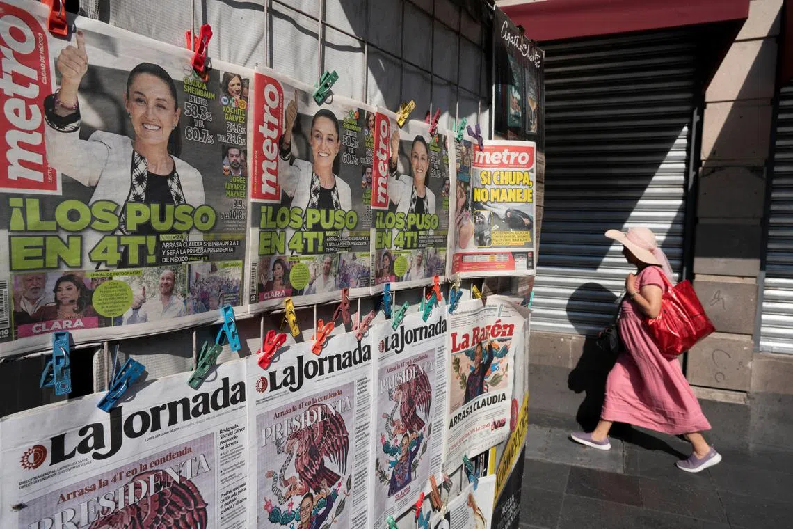 A woman walks past newspapers displaying the victory of the presidential candidate of the ruling Morena party Claudia Sheinbaum, a day after the general election, in Mexico City, Mexico June 3, 2024. REUTERS/Alexandre Meneghini/ File Photo