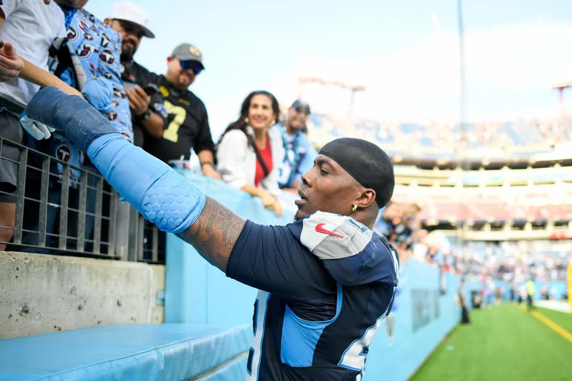 FILE PHOTO: Nov 3, 2024; Nashville, Tennessee, USA;  Tennessee Titans safety Quandre Diggs (28) gives a fan his elbow pad against the New England Patriots during post game at Nissan Stadium. Mandatory Credit: Steve Roberts-Imagn Images/File Photo