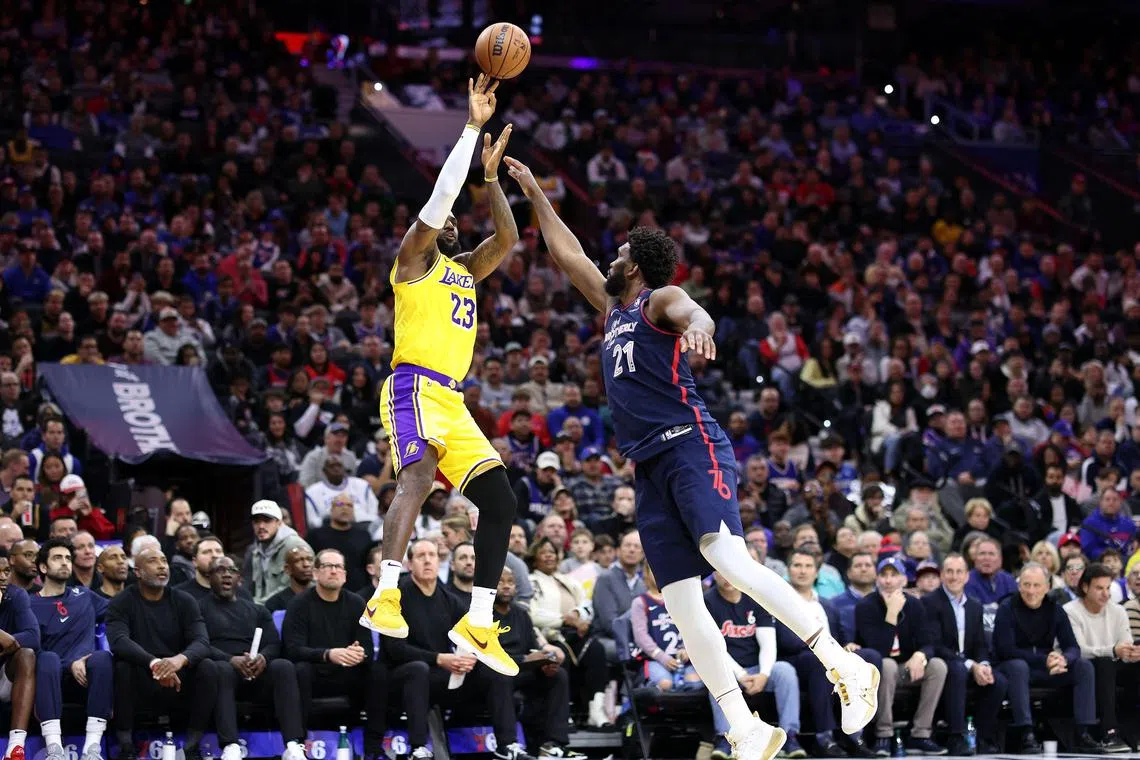 LeBron James of the Los Angeles Lakers shooting past Joel Embiid of the Philadelphia 76ers in their NBA game. 