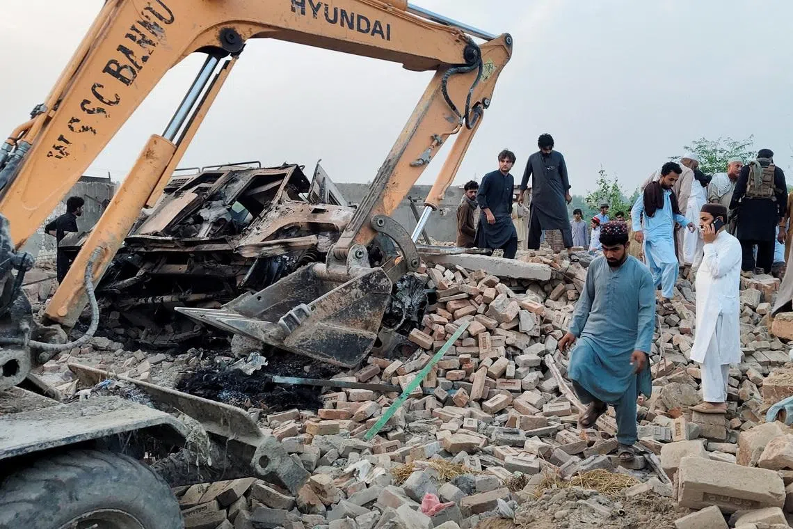 Residents gather on the rubble of a damaged police post after a car bombing on May 10.