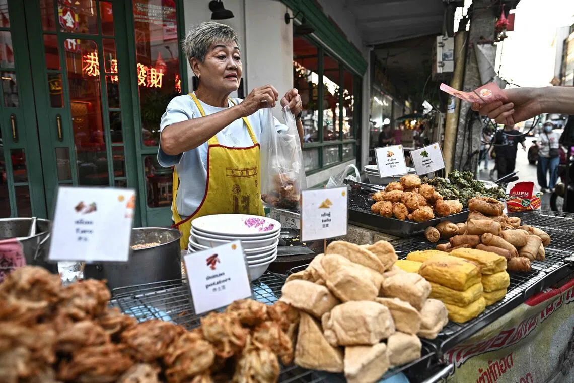 Street food vendor Thitisakulthip Sang-uamsap sells fried vegetarian snacks in Chinatown in Bangkok on April 30.