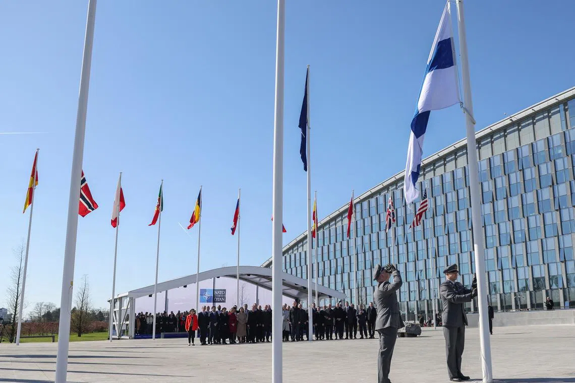 Finnish military personnel raising the Finnish national flag at the Nato headquarters in Brussels on April 4, 2023.