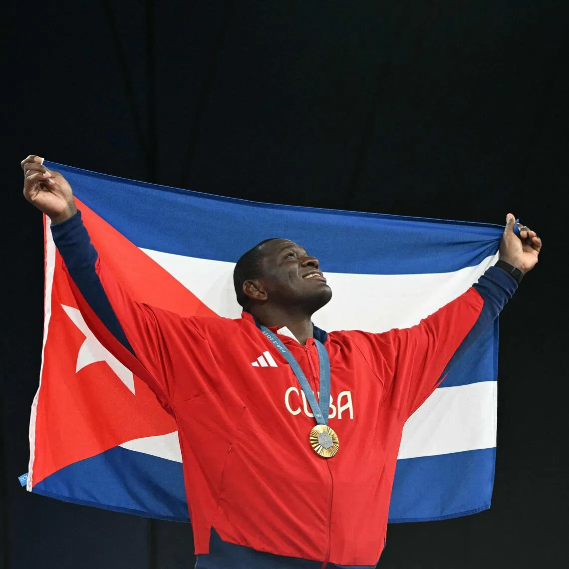 Cuba's Mijain Lopez Nunez poses with the Cuban flag and his gold medal during the Paris 2024 Olympic Games.