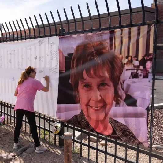 Actress Jennifer Bond signs a banner that reads "Bring her home" and shows a photo of Nancy Guthrie who went missing on Feb 1.