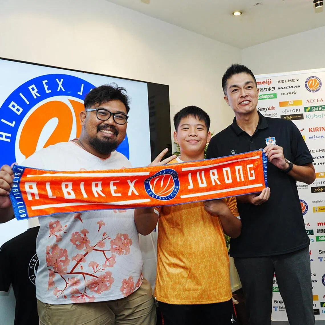 From right: Albirex Niigata chairman Daisuke Korenaga unveiling the club's new name Albirex Jurong and new emblem alongside fans Toby Jiang and Amir Hamizan.