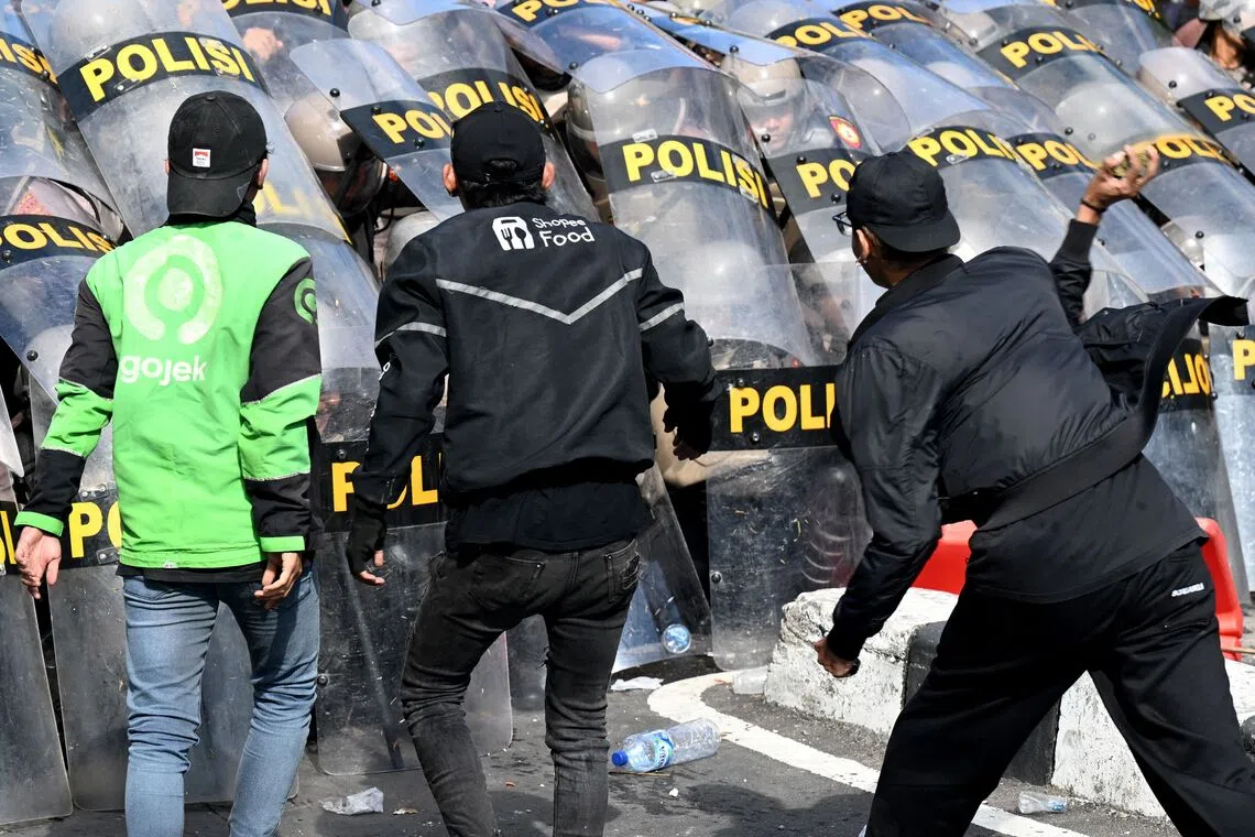 Protesters charging against police during a demonstration in front of the Bali police station in Denpasar on Aug 30.