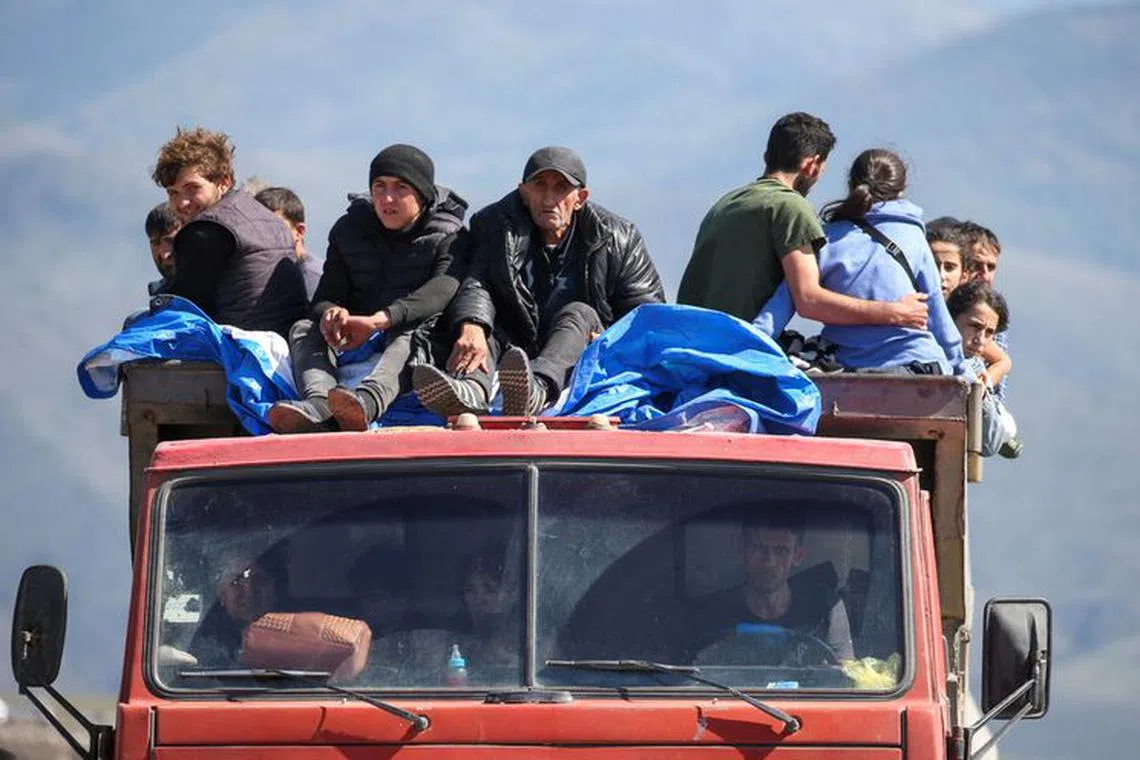 Refugees from Nagorno-Karabakh region ride in a truck upon their arrival at the border village of Kornidzor, Armenia, September 27, 2023. REUTERS/Irakli Gedenidze     TPX IMAGES OF THE DAY