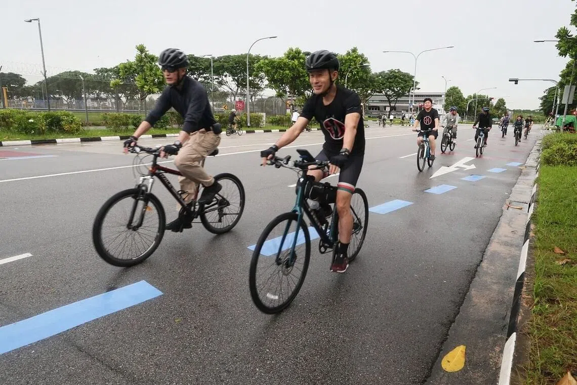 Senior Parliamentary Secretary for Transport Baey Yam Keng (right) marking the launch of the Sunday Cycling Lane with an inaugural ride with avid cyclists on Oct 16, 2022.