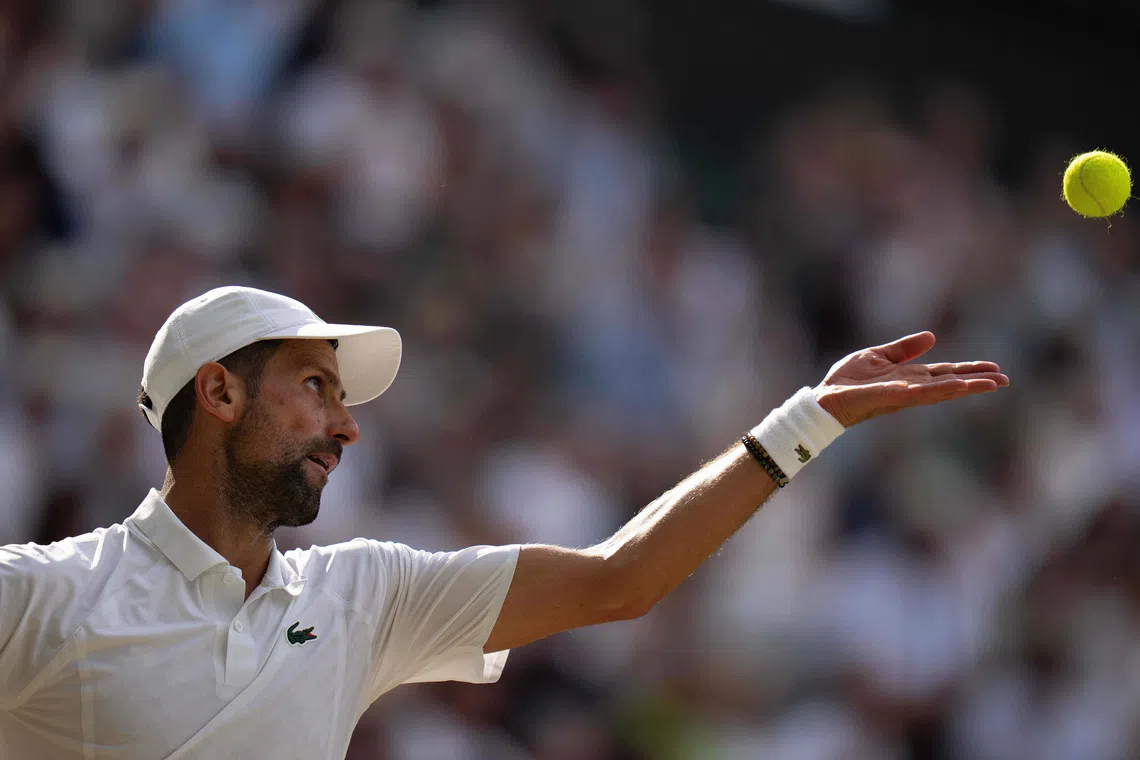 Novak Djokovic tosses the ball to serve during his Wimbledon semi-final match against Jannik Sinner.