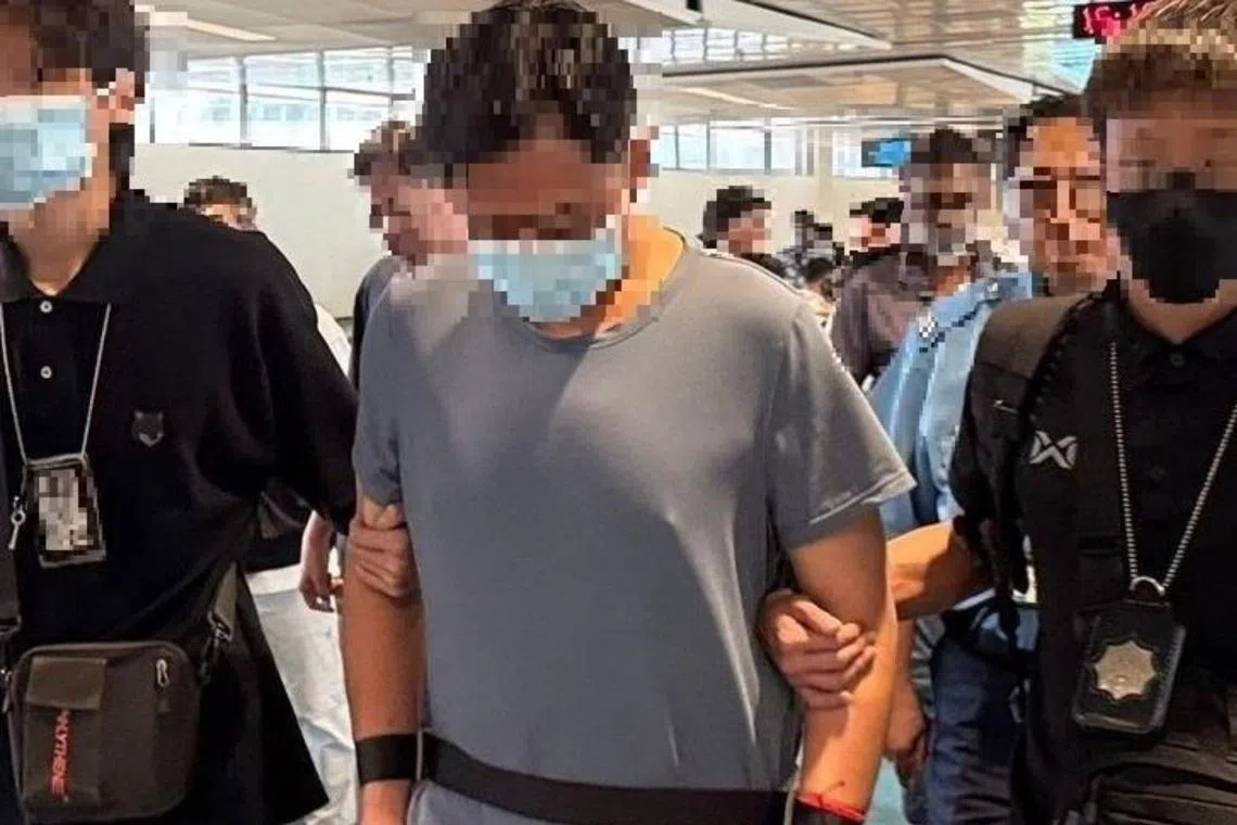 The 50-year-old man (centre) arrested by CNB officers on July 9.