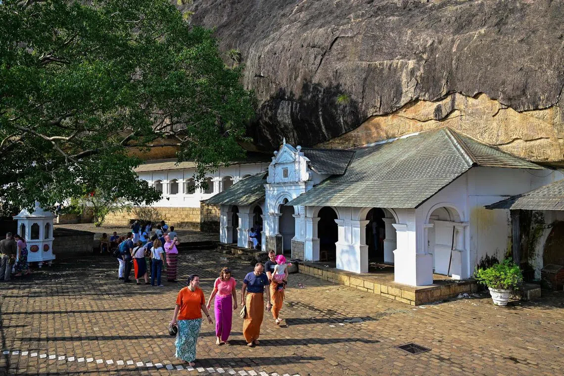 Foreign tourists visit the Rangiri Dambulla Cave Temple in Dambulla, some 150 Km (93 Miles) north of Sri Lanka's capital Colombo on February 15, 2024. (Photo by Ishara S. KODIKARA / AFP)