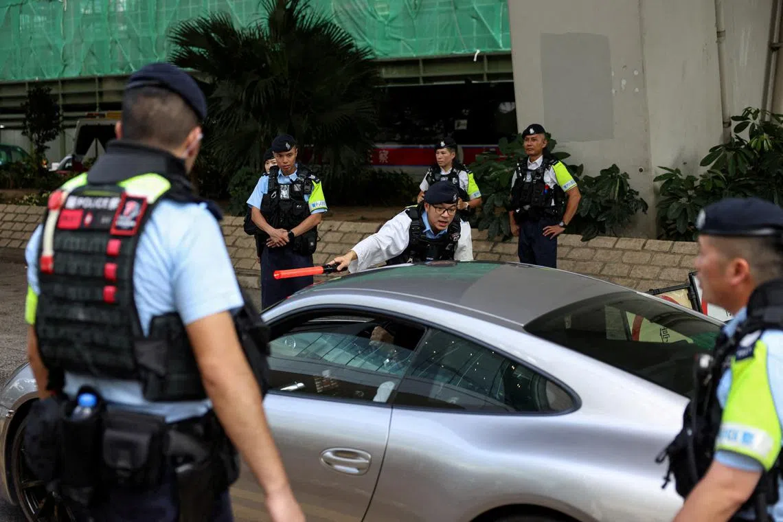FILE PHOTO: Police officers stand guard at the West Kowloon Magistrates' Courts building, ahead of hearing appeals from 12 jailed pro-democracy activists in Hong Kong, China, July 14, 2025. REUTERS/Tyrone Siu/File Photo
