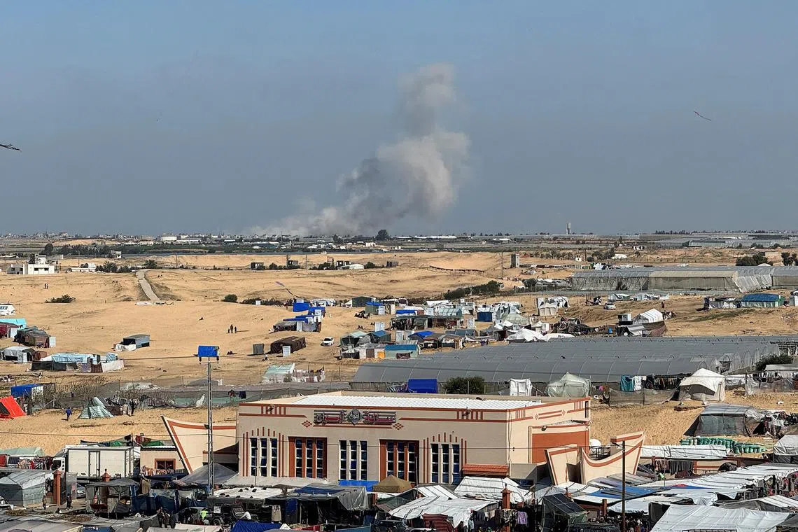 Smoke rises during an Israeli ground operation in Khan Younis, as seen from a tent camp sheltering displaced Palestinians in Rafah, in the southern Gaza Strip.