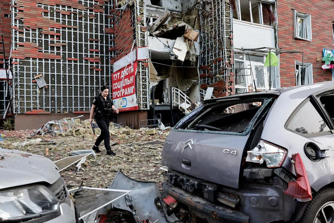 A police investigator walking near an apartment building damaged by a Russian drone strike, in Ukraine's capital, Kyiv, on June 10.