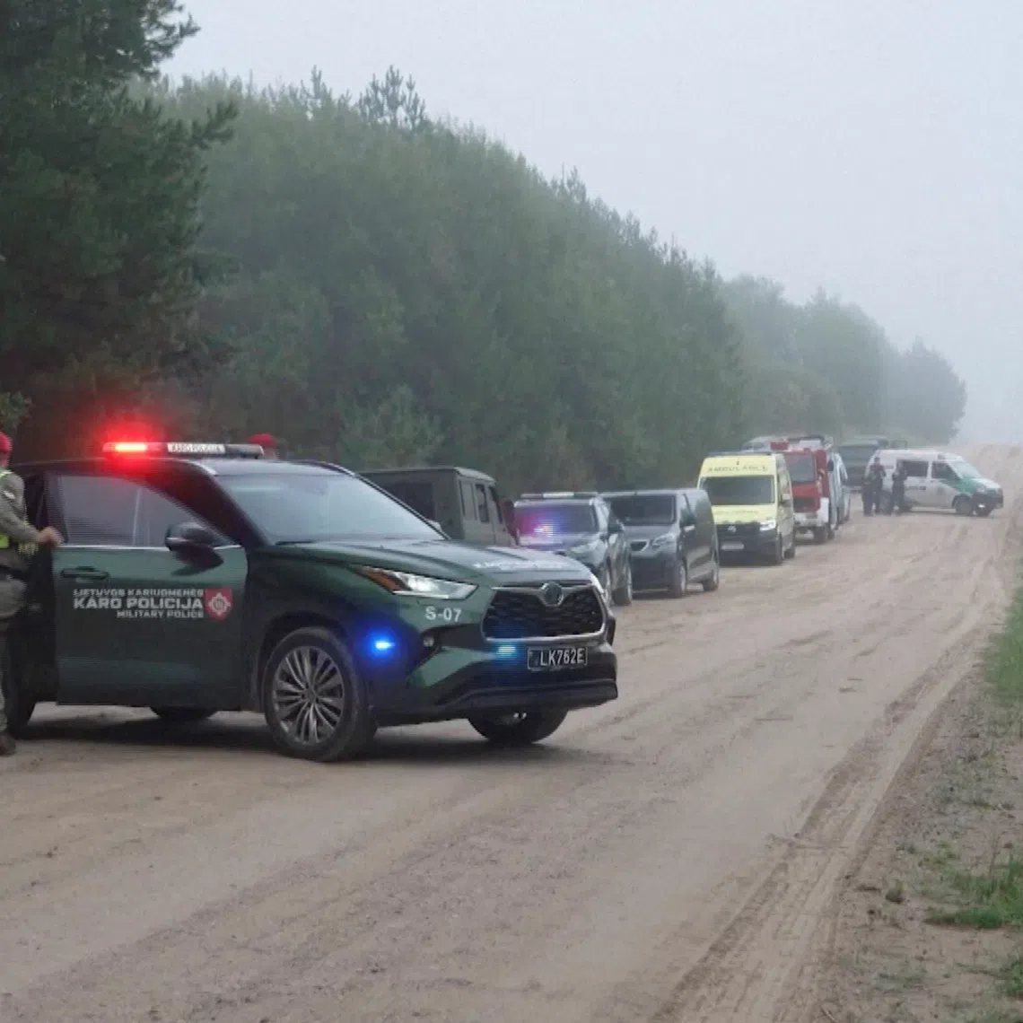 Military police and response vehicles stand parked near the site where, according to the Lithuanian national crisis management centre, a NATO fighter jet shot down a drone near Pratkunai village, Lithuania, September 15, 2026, in this screengrab from a handout video. Lithuanian Army/Handout via REUTERS
