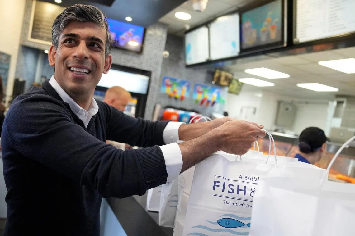 British Prime Minister Rishi Sunak buying fish and chips for the media, during an election campaign visit to Redcar, in north-east England, on June 28.