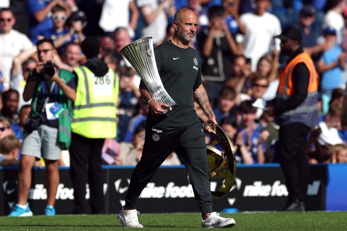 Soccer Football - Friendly - Chelsea v AC Milan - Stamford Bridge, London, Britain - August 10, 2025 Chelsea manager Enzo Maresca carries the Club World Cup trophy and the UEFA Conference League trophy on the pitch after the match Action Images via Reuters/Paul Childs