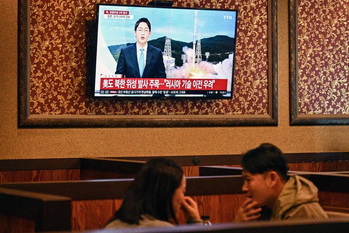 A TV at a restaurant in Seoul shows a news broadcast, following claims by North Korea that it launched a military spy satellite.