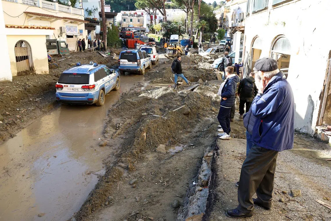 People gather at the scene following a landslide on the Italian holiday island of Ischia, Italy, Nov 27, 2022.