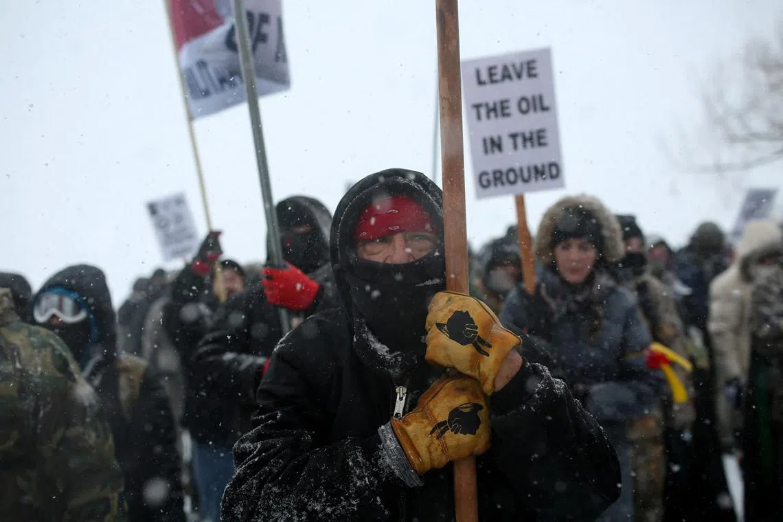 FILE PHOTO: A Native American man leads a protest march with veterans and activists outside the Oceti Sakowin camp where "water protectors" continue to demonstrate against plans to pass the Dakota Access pipeline adjacent to the Standing Rock Indian Reservation, near Cannon Ball, North Dakota, U.S., December 5, 2016.  Picture taken December 5, 2016.   REUTERS/Stephen Yang/File Photo
