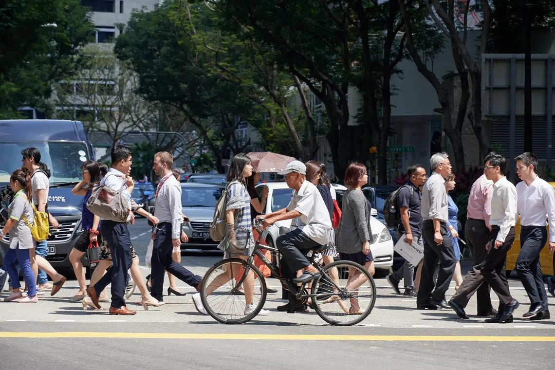 People crossing the road at the traffic light junction in the CBD area on 19 March 2018. Also seen crossing is an elderly man on his bicycle.